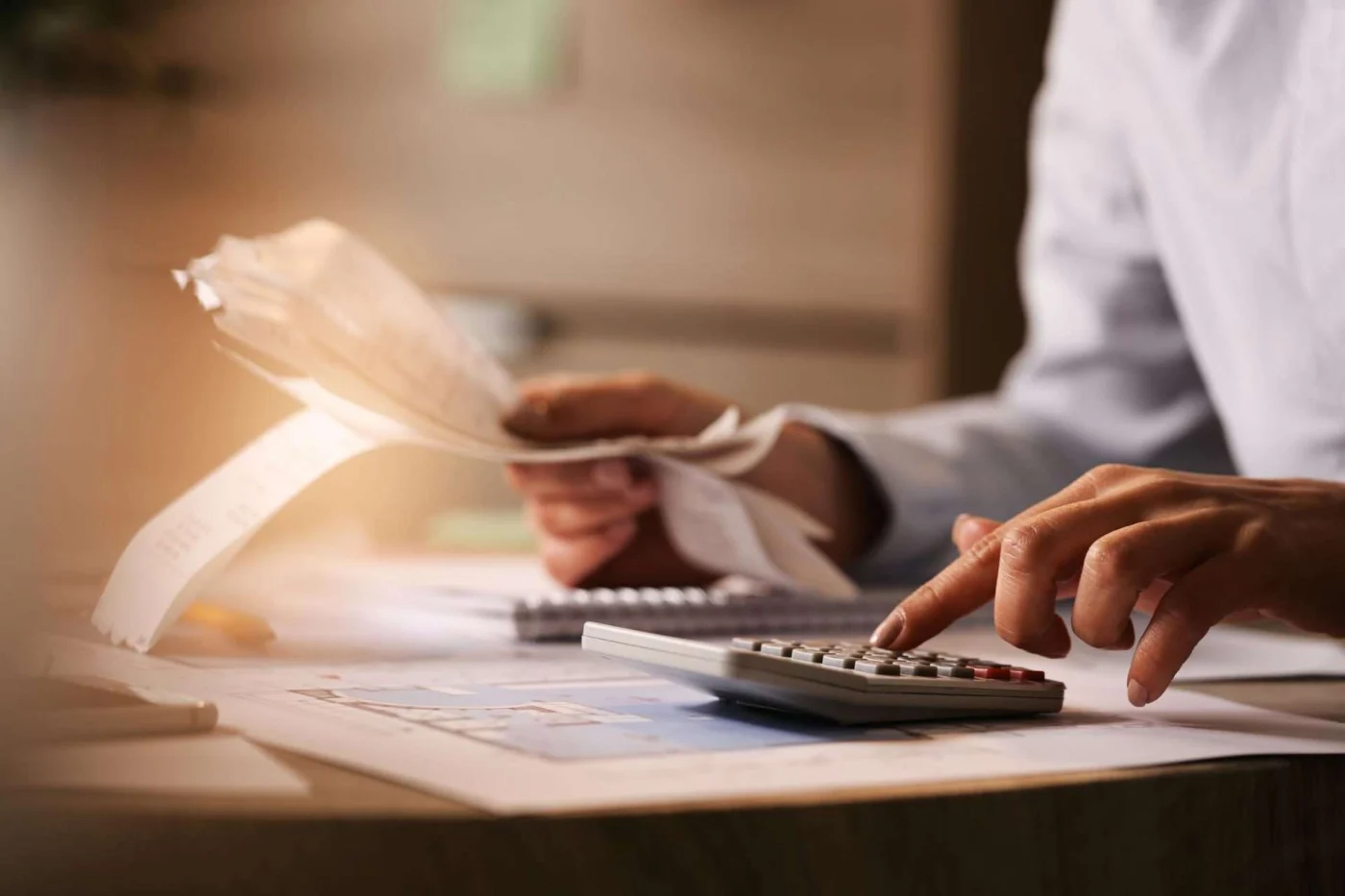 Homeowner using calculator to budget remodel project, highlighting benefits of financing amid rising inflation