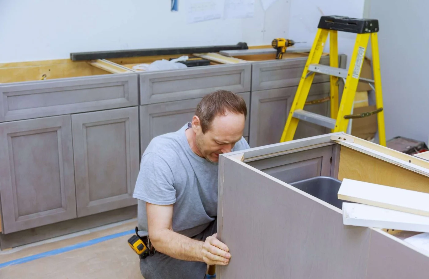 Home improvement contractor installing custom kitchen cabinets, a top upgrade for return on investment