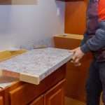 Carpenter working on kitchen renovation, representing benefits of remodeling kitchen and bathroom together