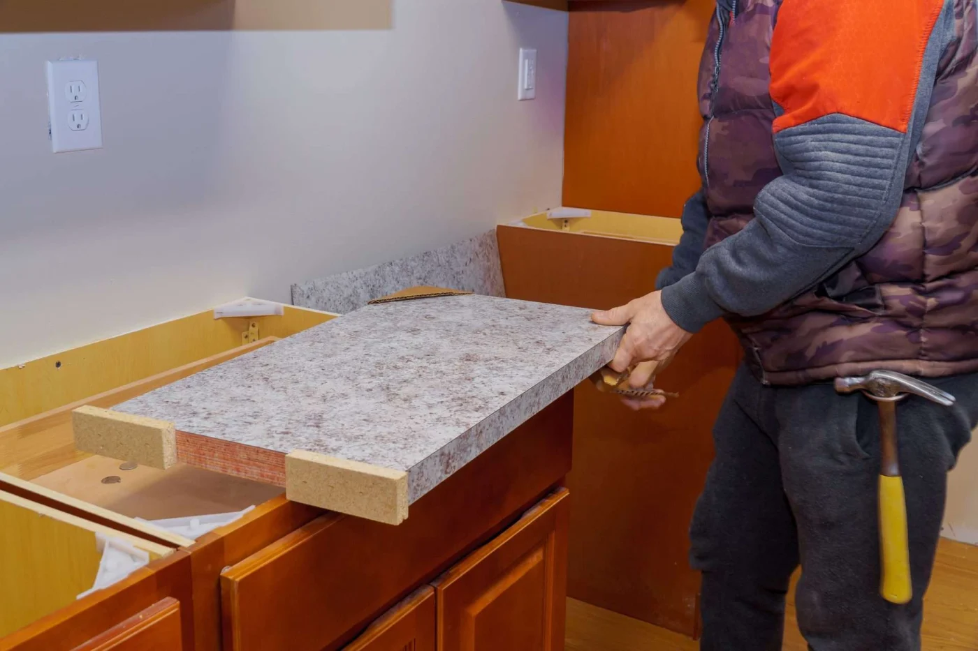 Carpenter working on kitchen renovation, representing benefits of remodeling kitchen and bathroom together