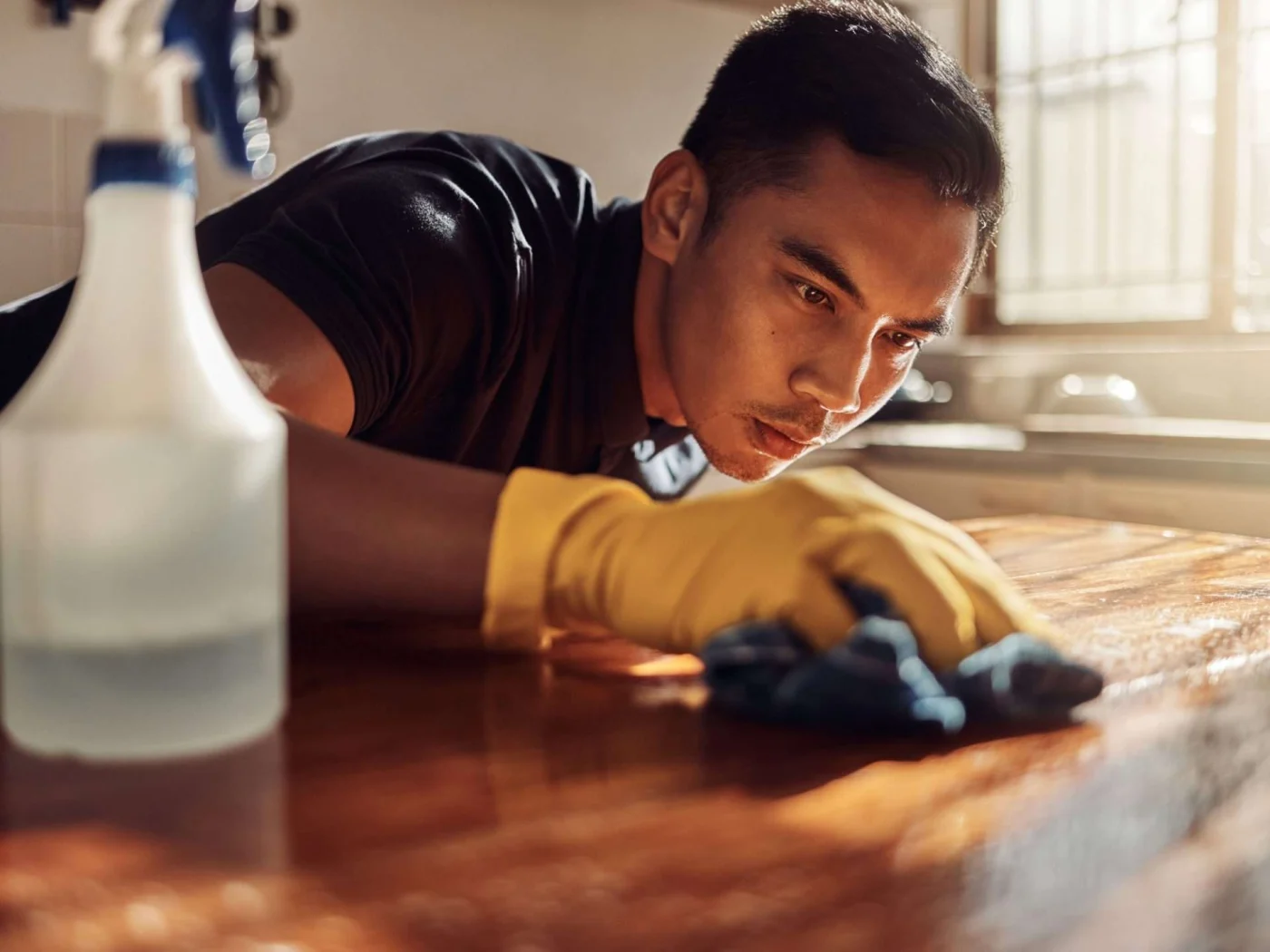 A man meticulously cleaning a coffee table