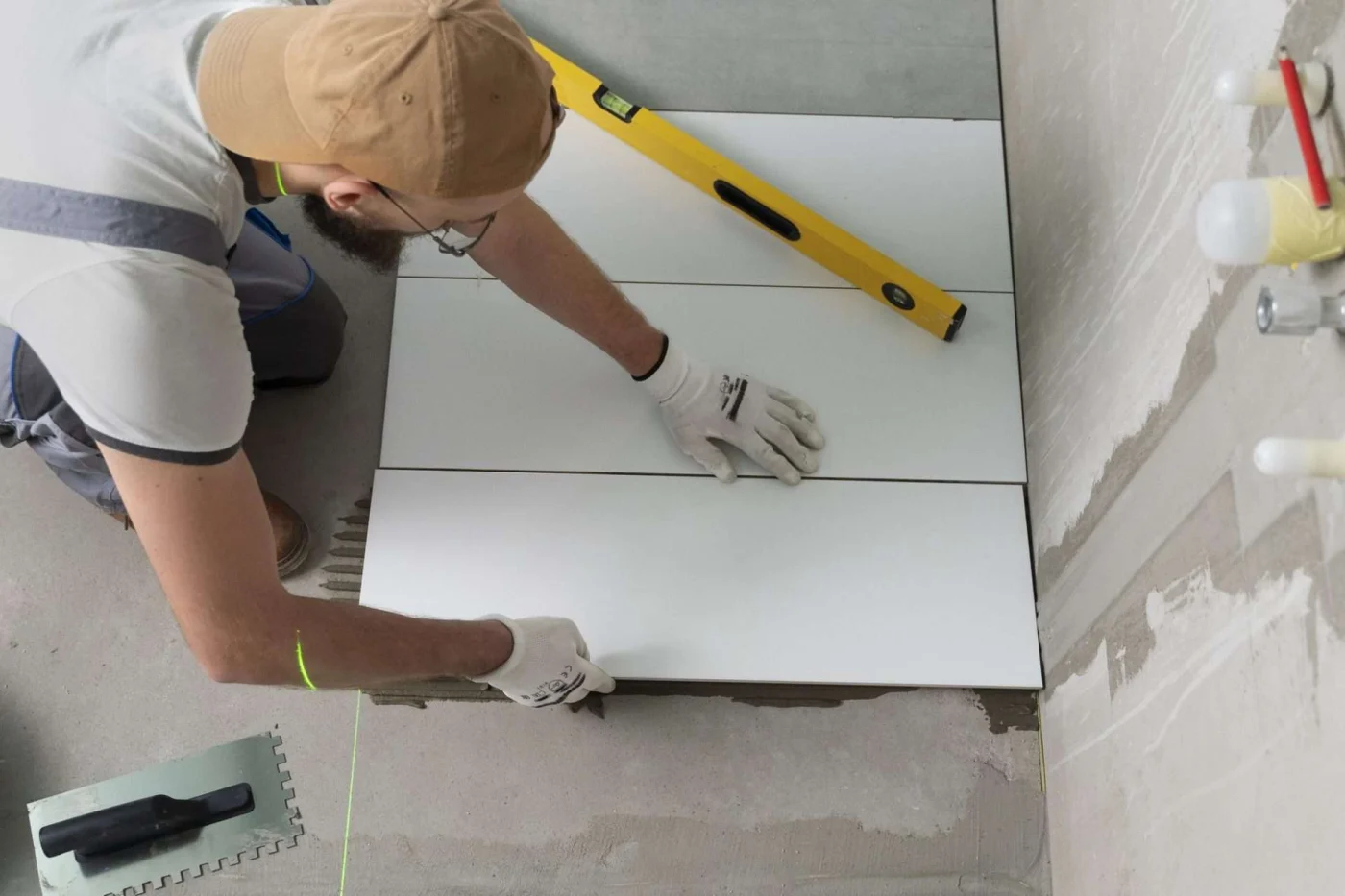 Bathroom remodeling professional tiling wall during one-day renovation in Kansas City apartment