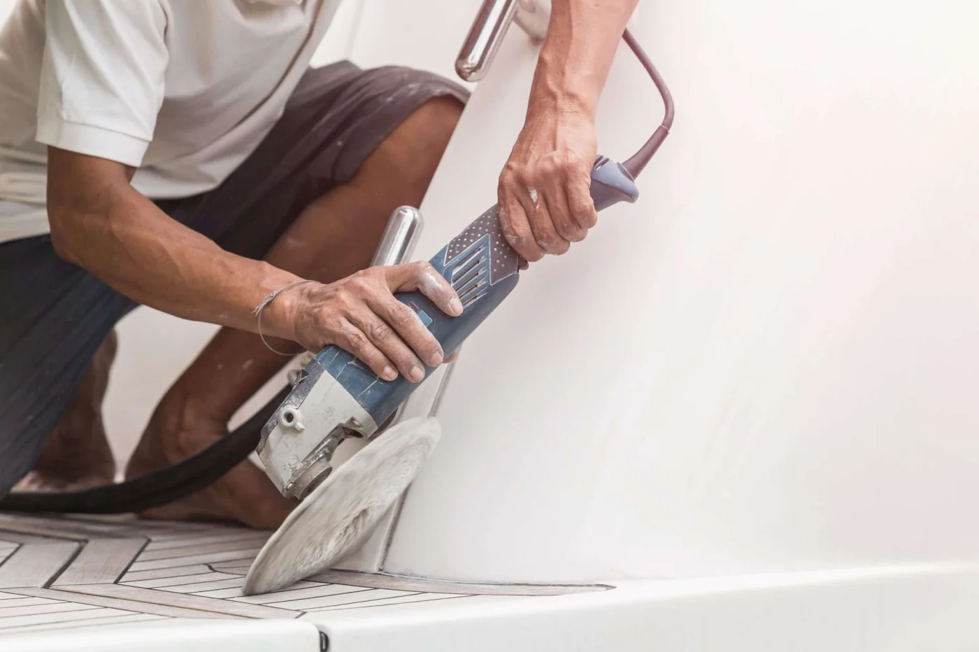 Man polishing surface with grinder tool, illustrating attention to detail in remodel projects