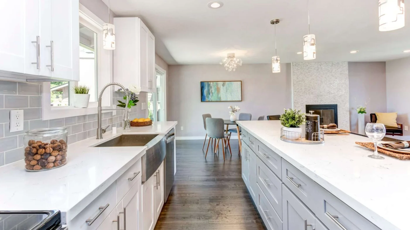 A kitchen with white cabinets, an island, and stainless steel appliances