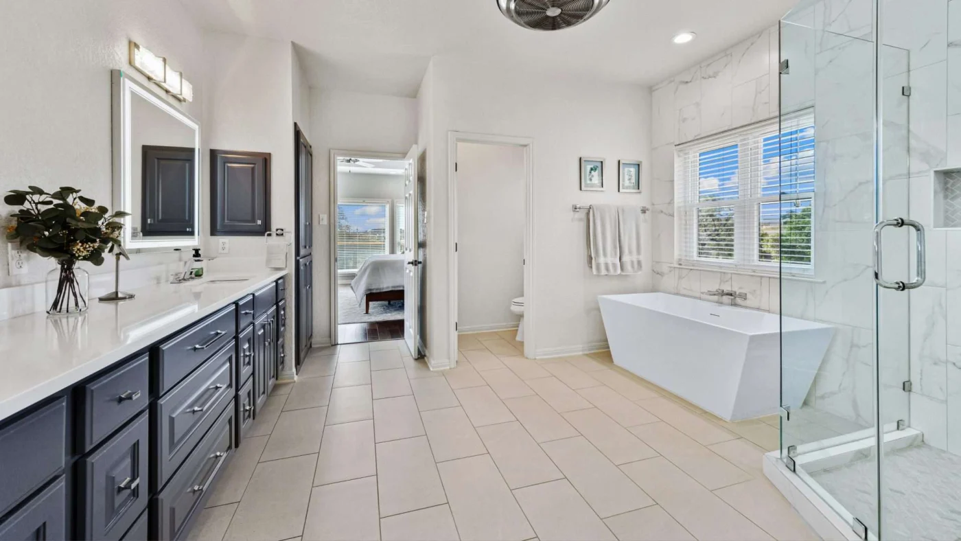 A large bathroom with a vanity, a walk-in shower, and a stand-alone tub