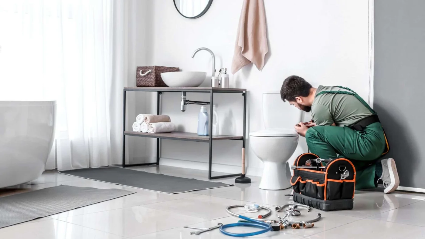 A bathroom remodeler finishes installing a new toilet