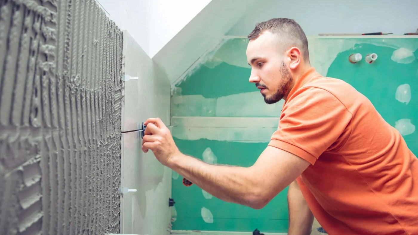 Close view of a tiler at work on a bathroom remodeling project