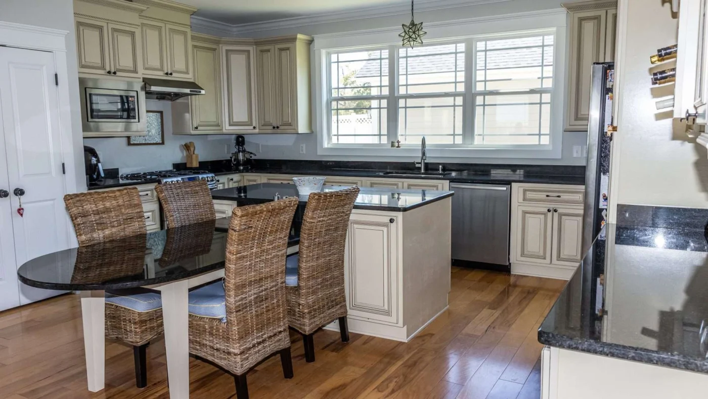 Remodeled kitchen with traditional off-white cabinets and dining set