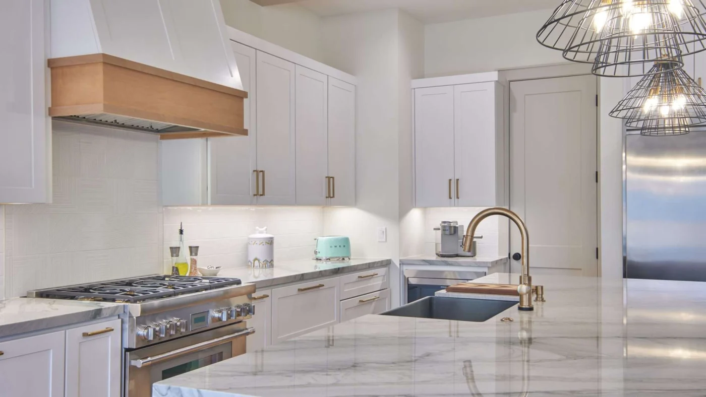 Contemporary kitchen with natural stone countertops and white cabinets