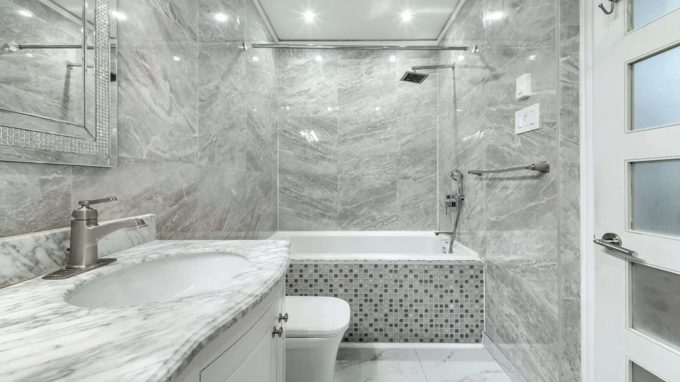 A gray and white themed bathroom with a tub/shower combo