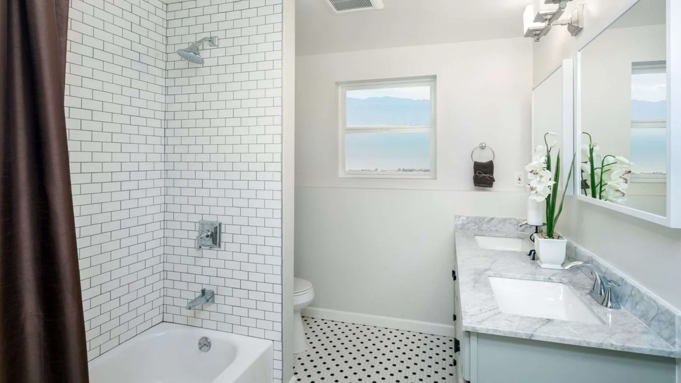 A bathroom with subway tile shower surrounds, a gray countertop, and a brown shower curtain