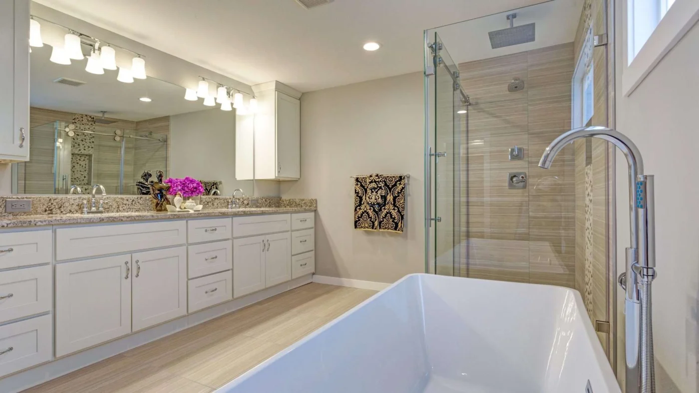 A bathroom with a large vanity, standalone tub, and walk-in shower