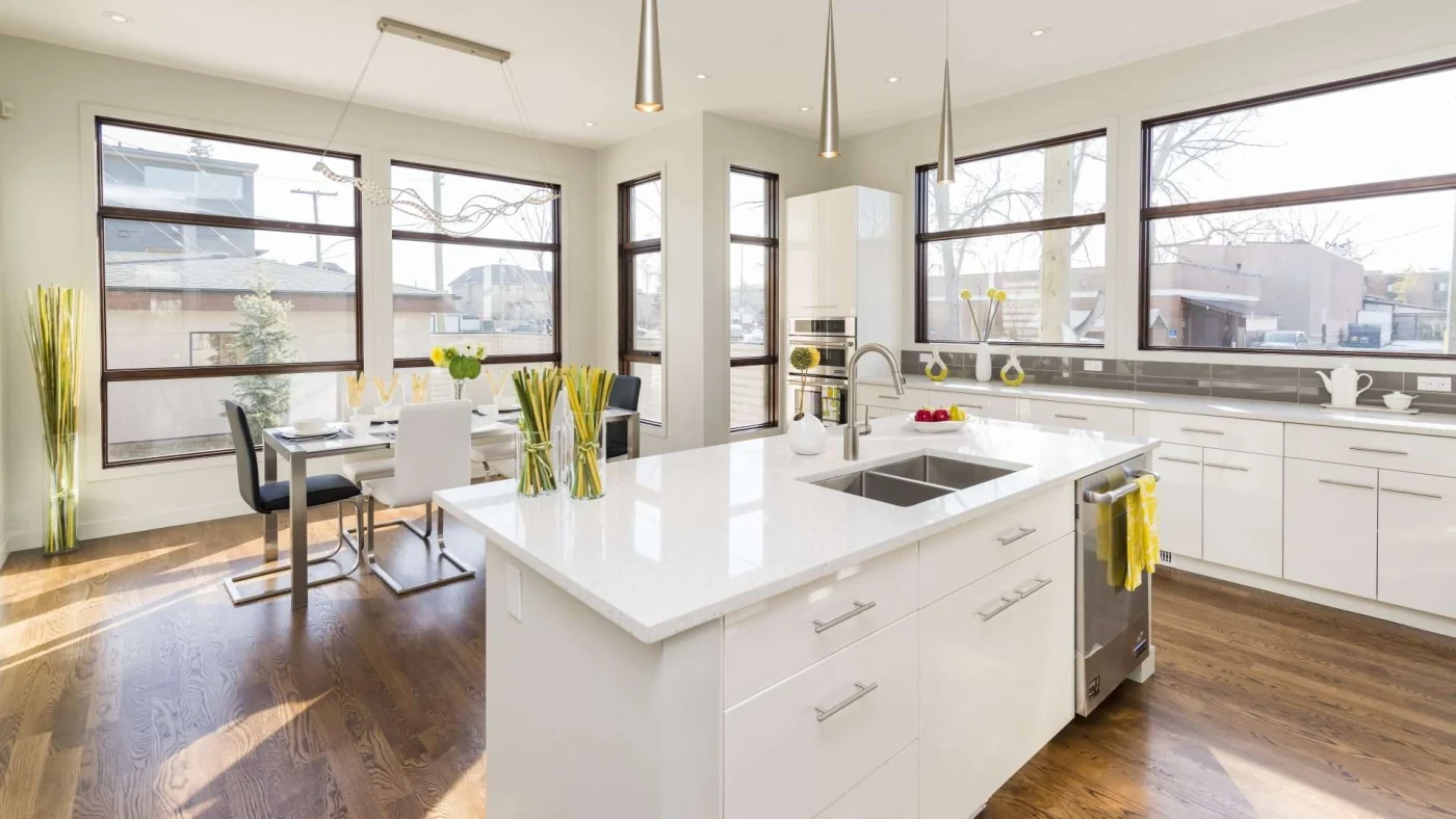 Beautiful kitchen remodel with white interior, island, cabinets, and big black-framed windows
