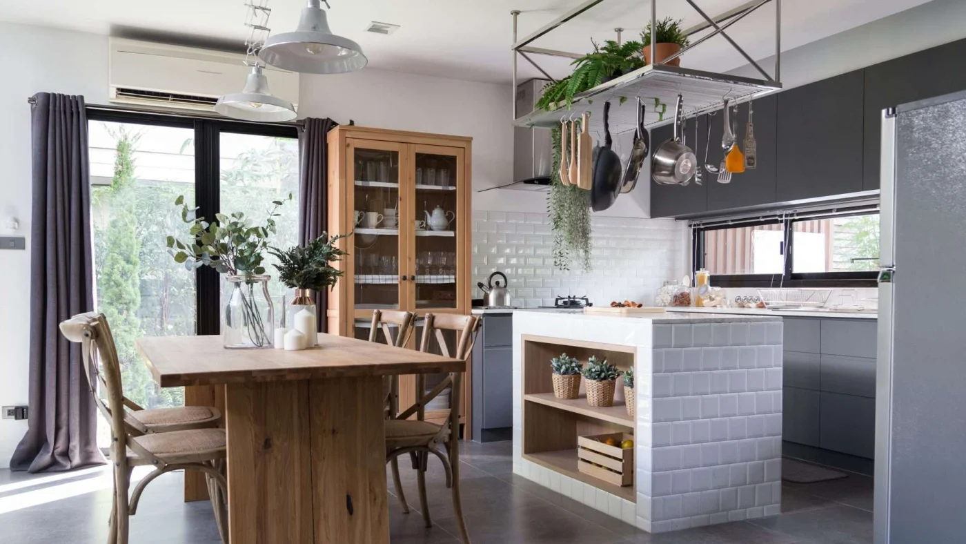 Angled view of a beautiful kitchen area with a dining table and a central island with overhead pan storage