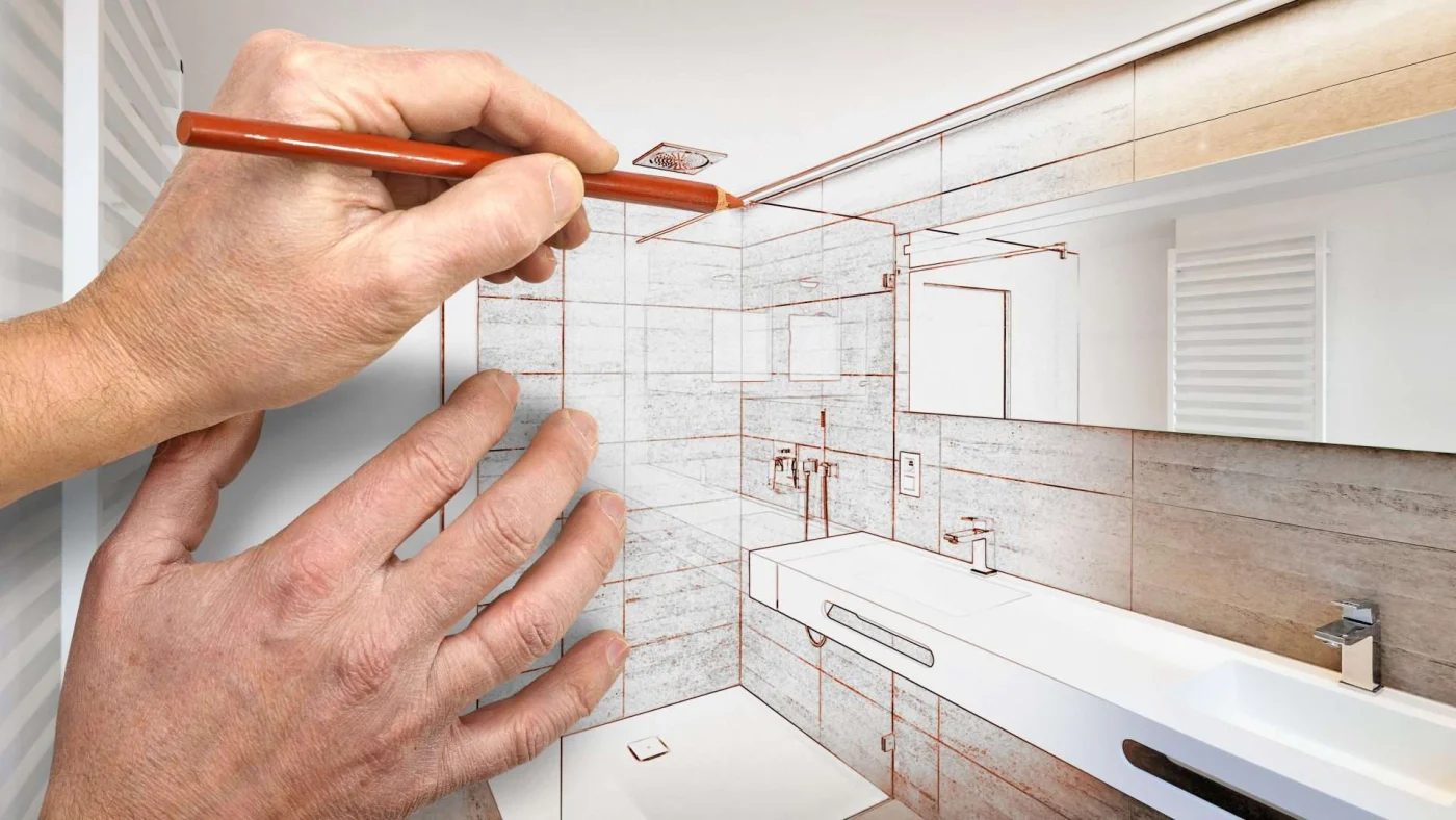 A hand sketches the finishing touches on a bathroom design