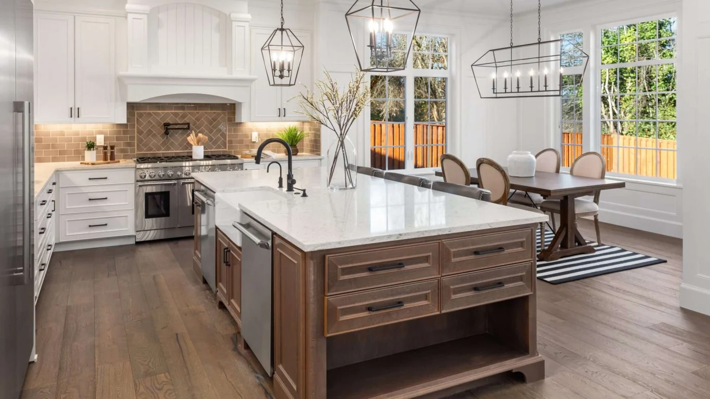 Shawnee, KS kitchen with beautiful middle bar with marble countertops, dark hardwood flooring, and gorgeous white cabinets