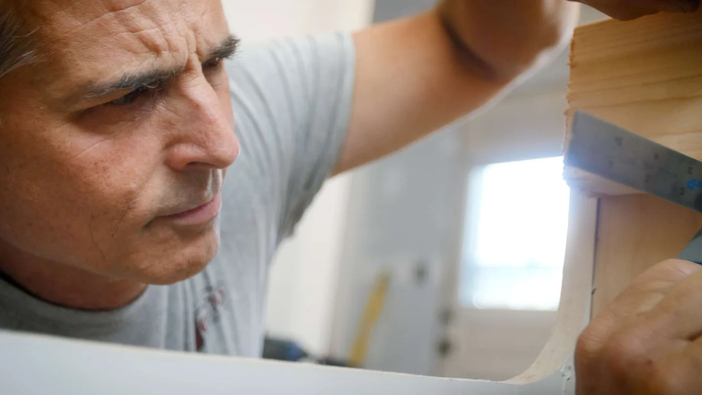Man measuring wall in kitchen