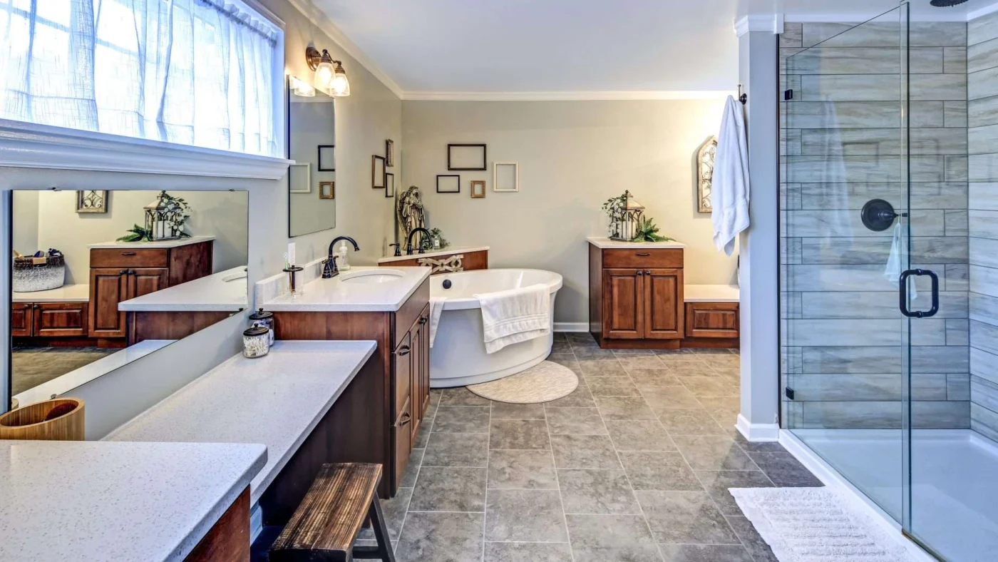 A large bathroom with brown cabinets, a walk-in shower, and a soaker tub