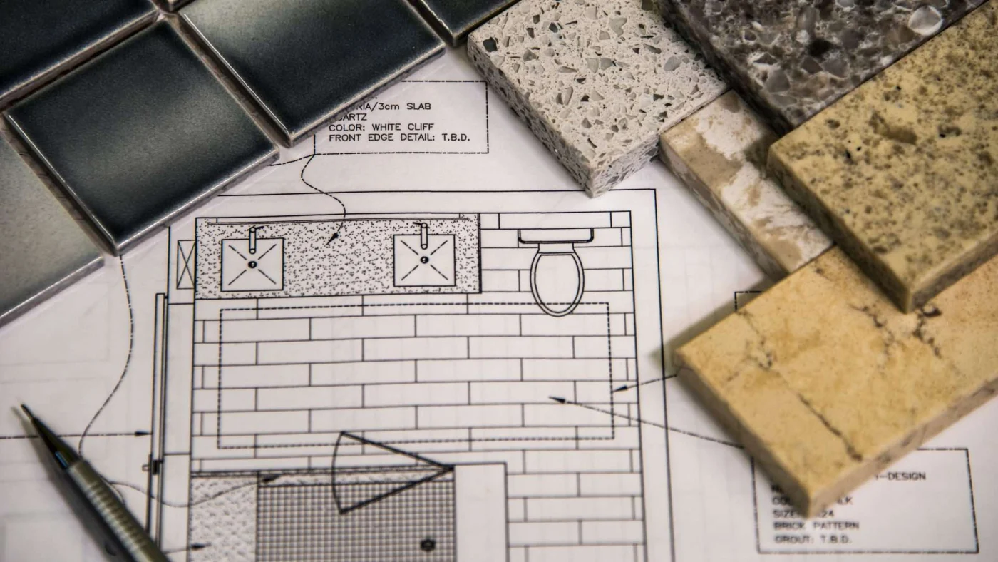 Different tile samples laying on top of bathroom remodeling design plans