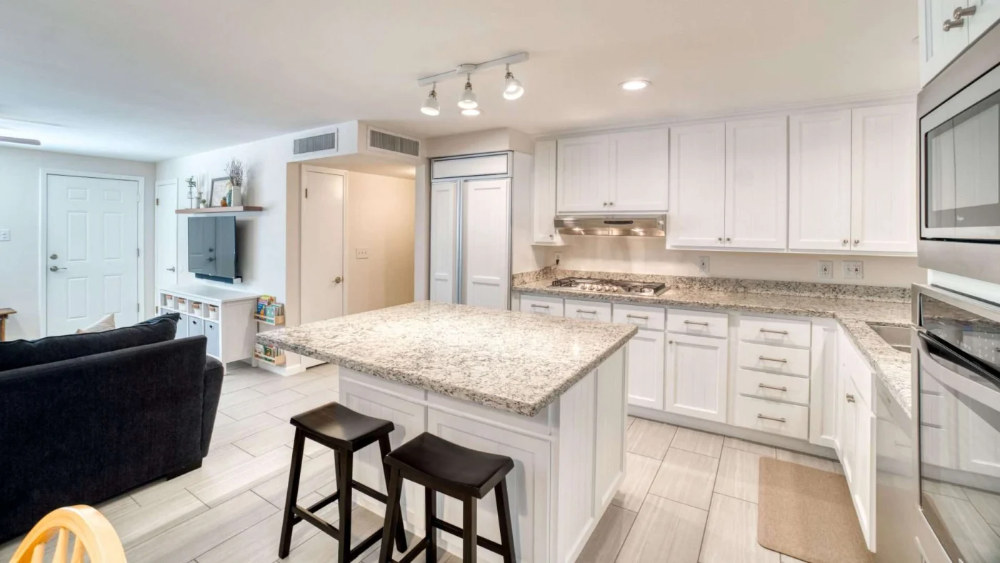 Newly remodeled kitchen in Kansas City, MO with granite countertops, white cabinets, and new tile flooring