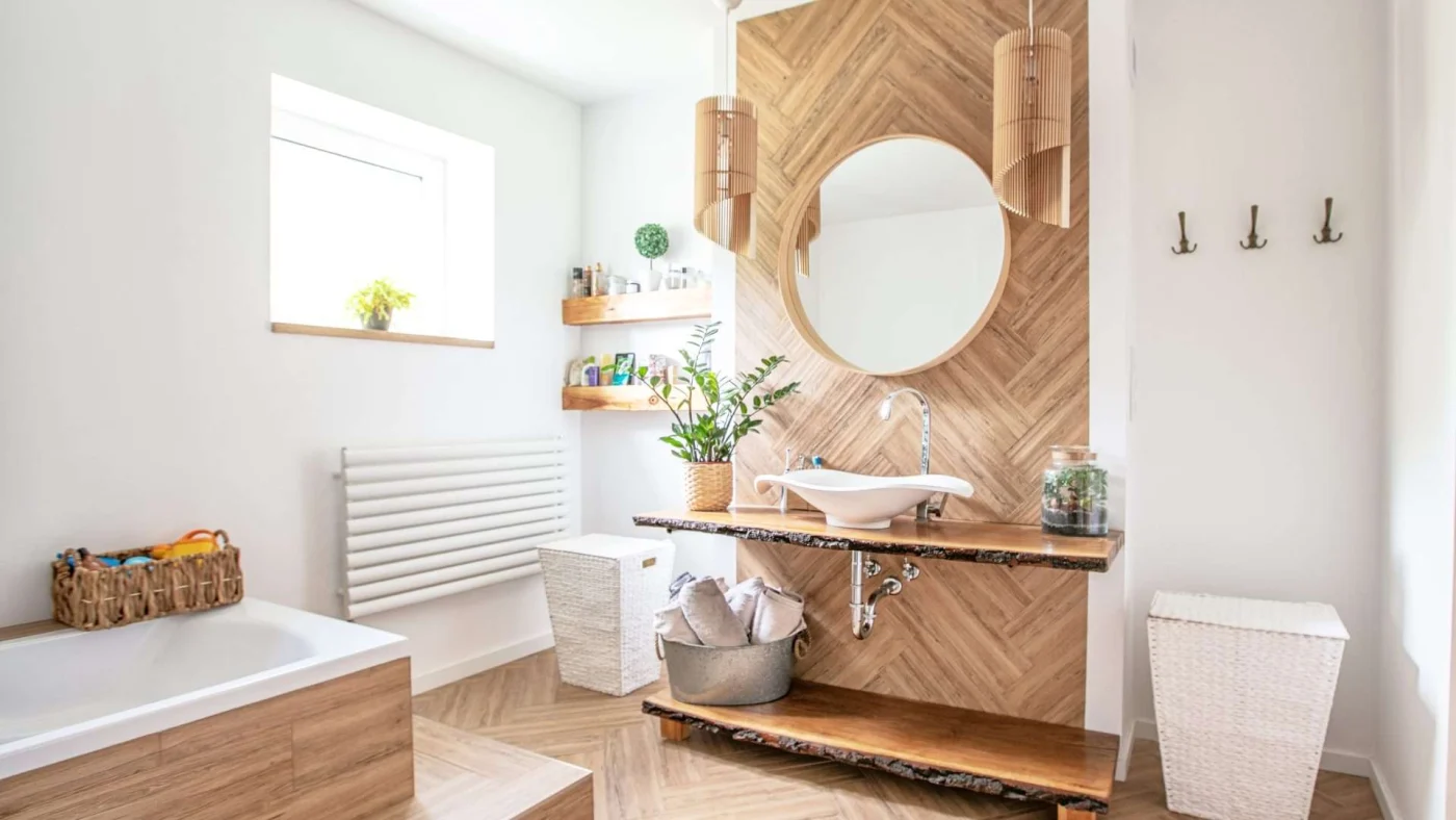 Interior view of a modern remodeled bathroom with a wood accent wall and wood-lined bathtub