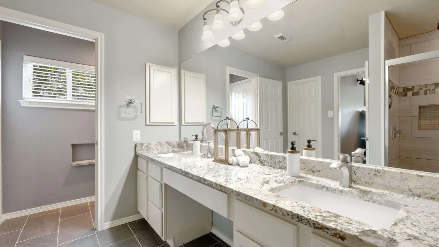 An expansive bathroom vanity with marble countertop and mirror