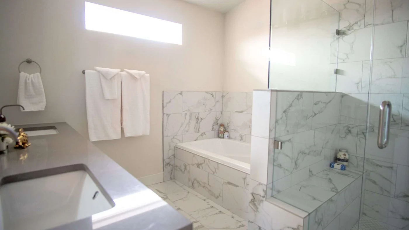A bathroom with a large double vanity, a walk-in shower, and a separate bathtub