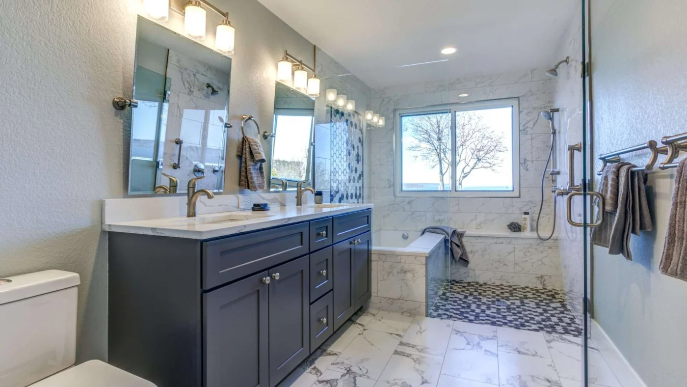 A bathroom with a large double vanity, a walk-in shower, and a separate bathtub