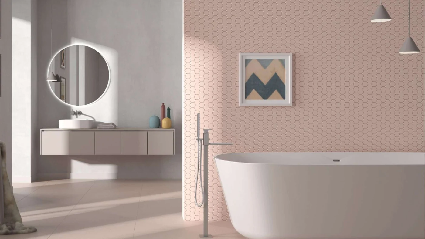 A bathroom with a large white tub, pink walls, and a vanity with round mirror