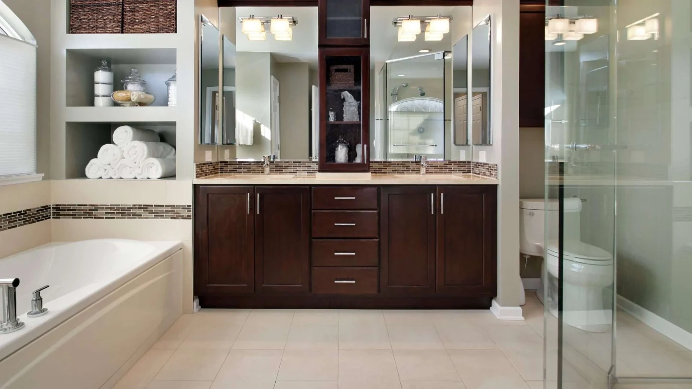 Frontal view of a wood double vanity in a beautiful bathroom with a separate tub and glassed-in shower