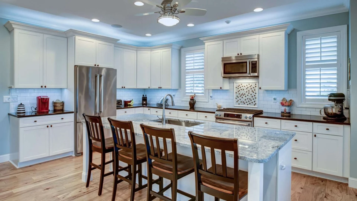 Spacious kitchen with white cabinets, light blue walls, and island