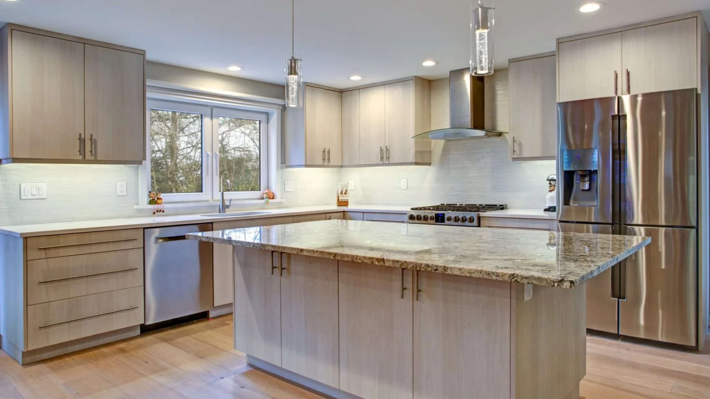 Newly remodeled kitchen with gray cabinets, wood flooring, and beautiful windows overlooking the sink