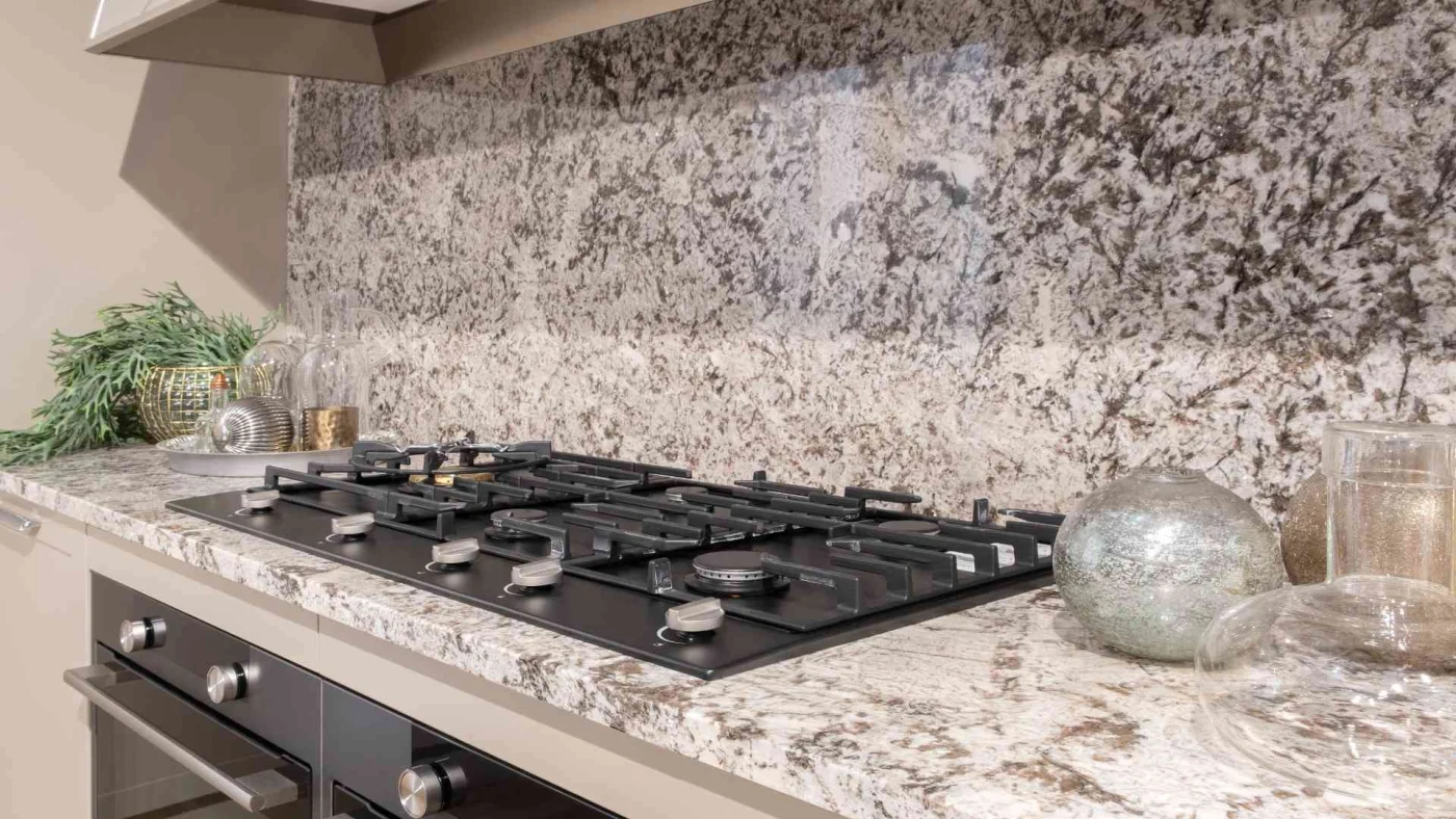 Home kitchen with modern stone, granite countertop, and beautiful stone backsplash