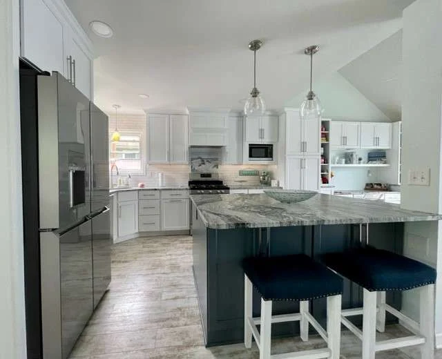 A kitchen recently refinished to include dark and light cabinets for a bold statement.
